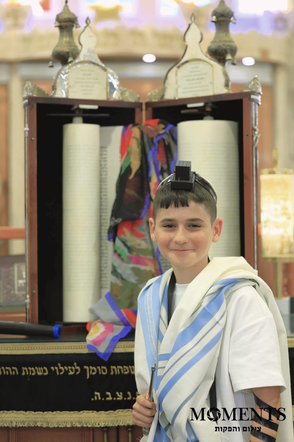חתן בר מצווה ליד ארון הקודש וספרי התורה